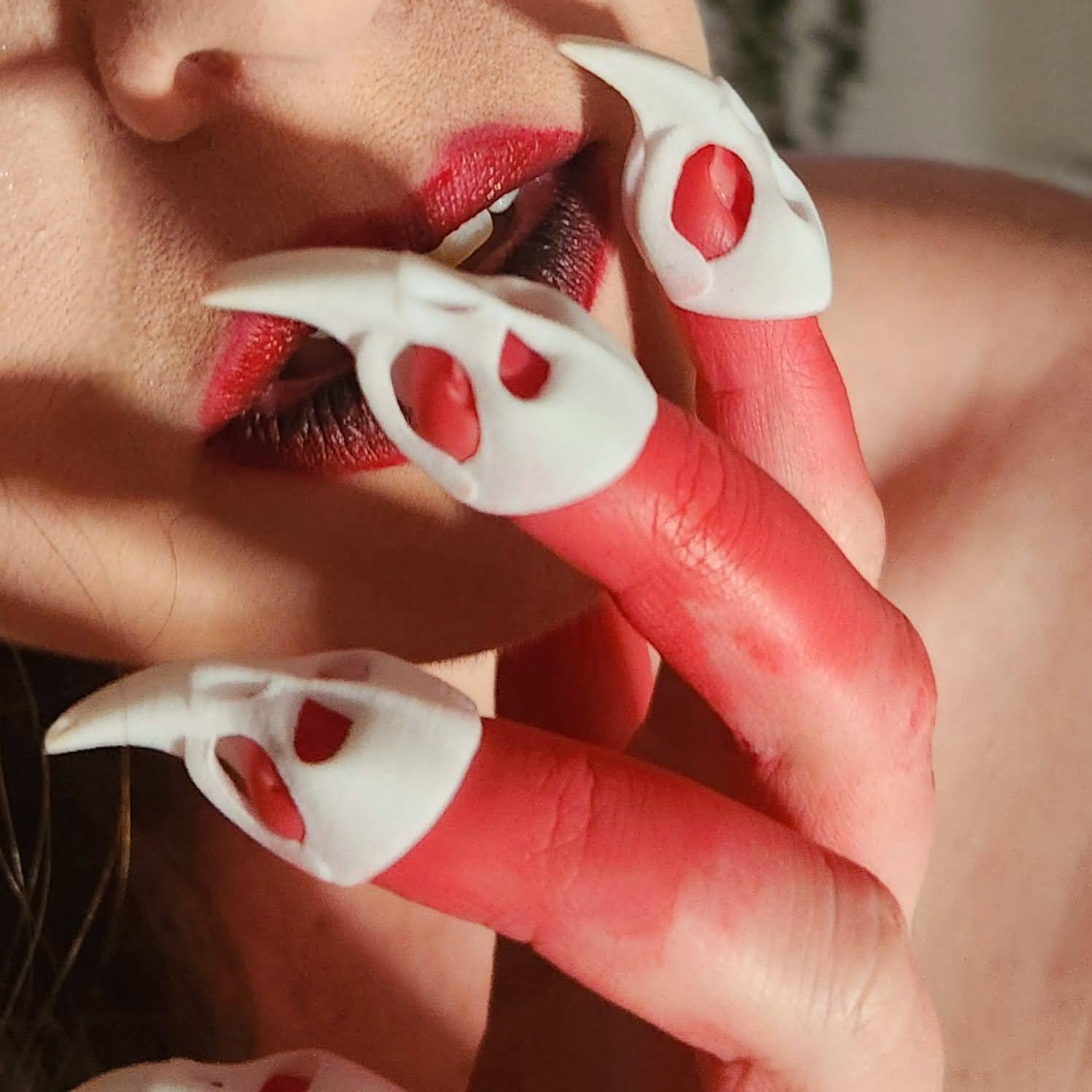 Lifestyle image of hand wearing BDSM Skull Claws holding chin and showing luscious lips