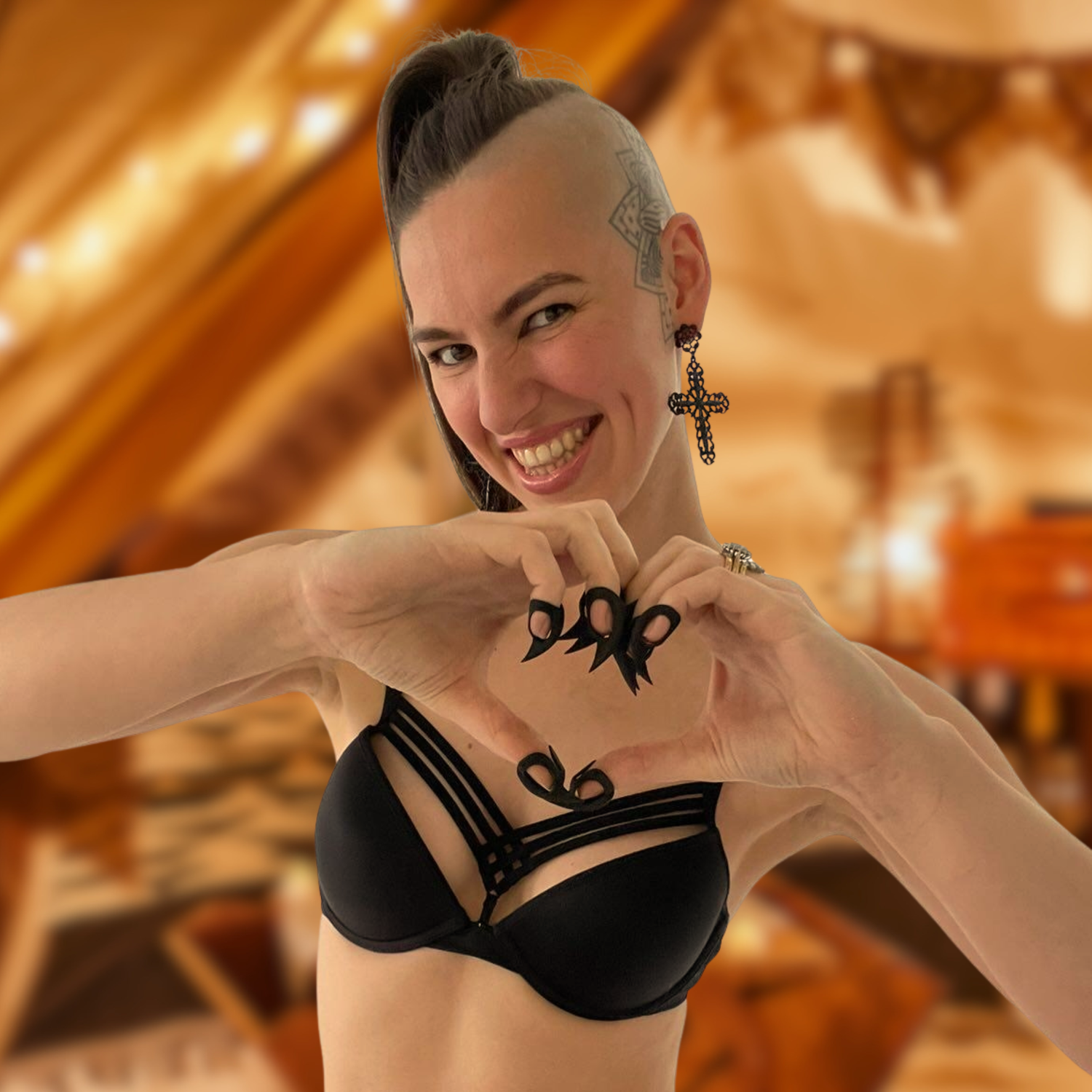 Young woman with a big smile. Wearing adult claws for sensation play while making a heart gesture and inviting connection.