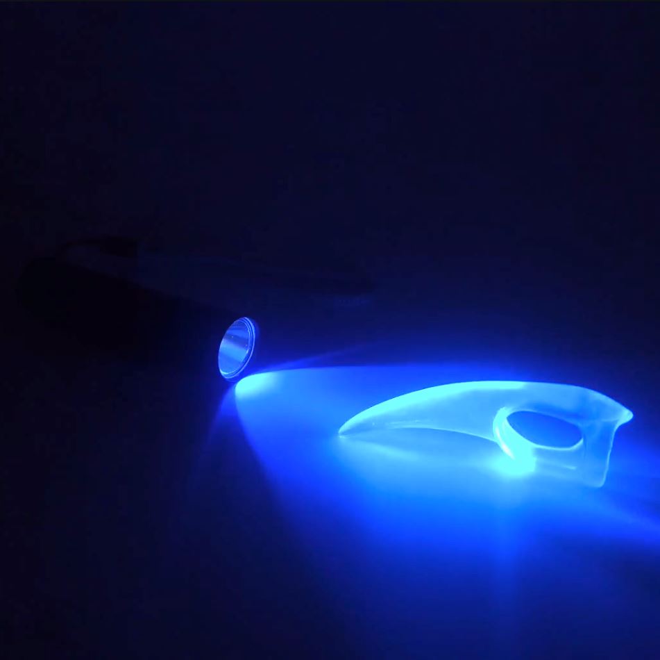 UV Torch for kink shown lighting up glowing fetish Claw for sensual play.